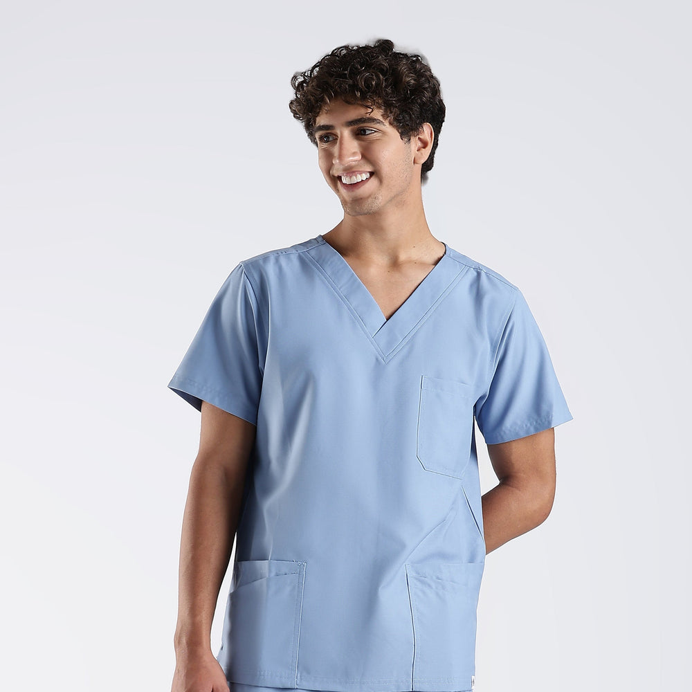 Person wearing a light blue scrub set on a white background